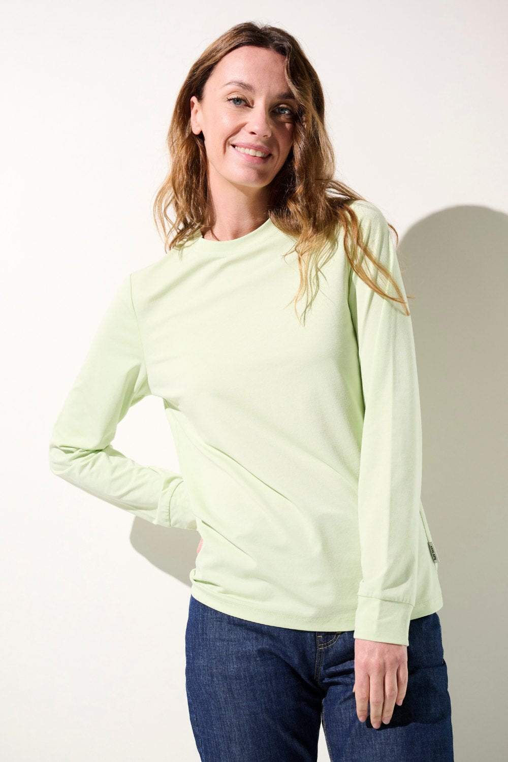 T-shirt anti-UV vert clair UPF 50+ pour femme, léger et confortable, idéal pour les activités extérieures.