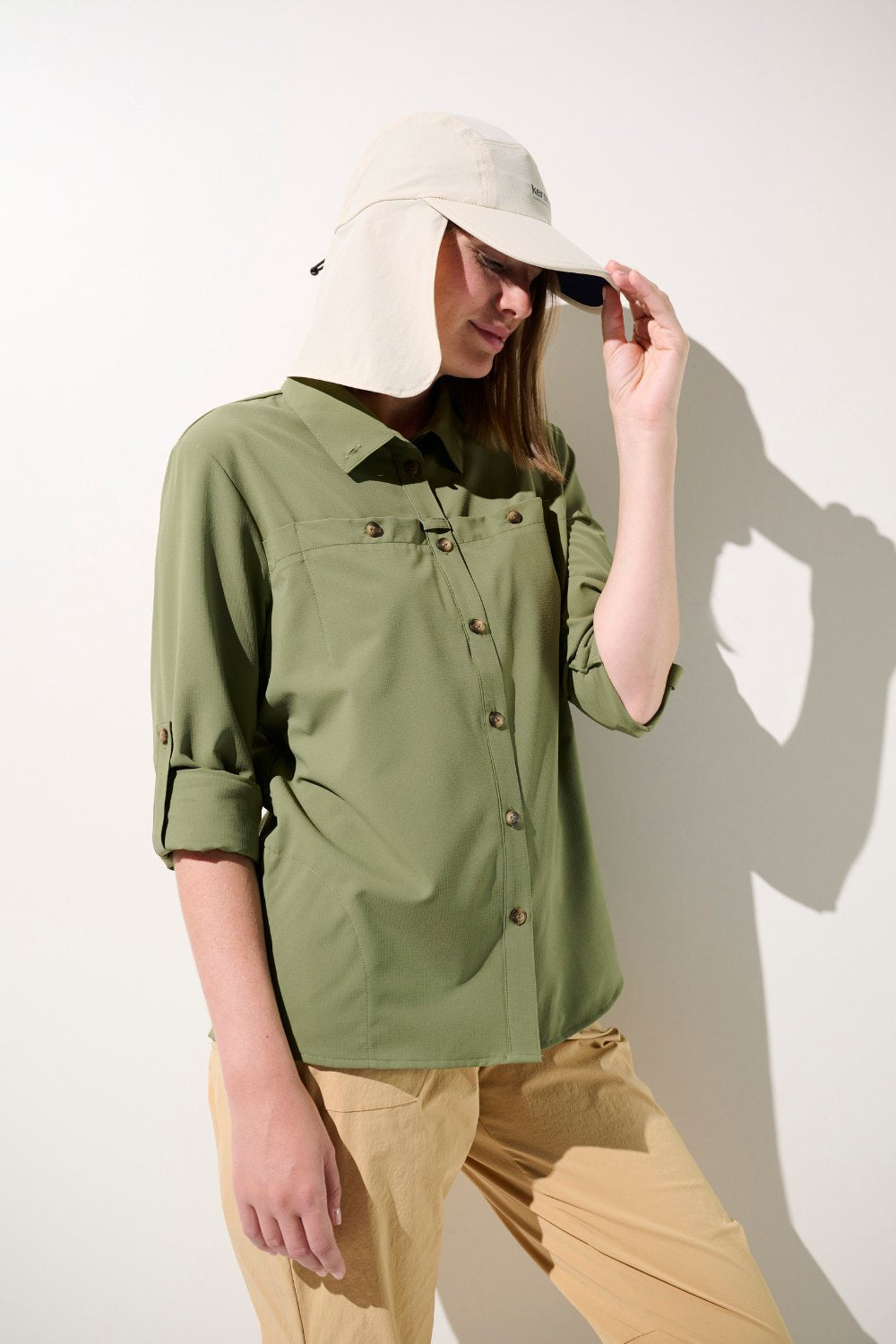 Femme portant une chemise anti-UV verte UPF 50+ et une casquette anti-UV Sequoia pour activités en extérieur.