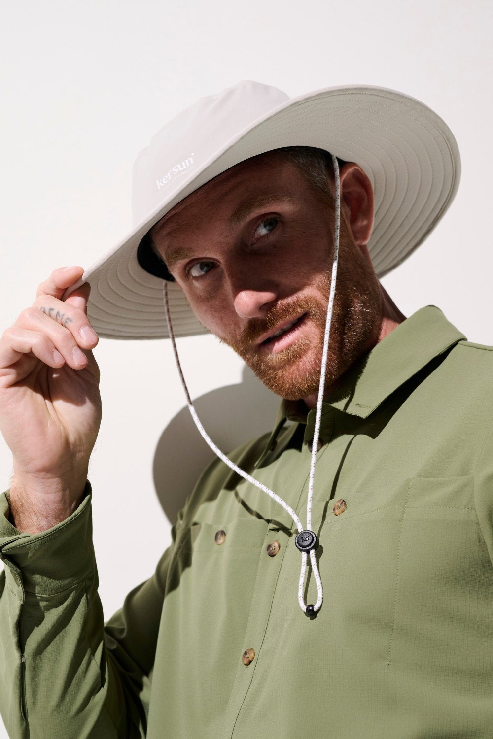 Chapeau anti-UV - Oasis beige UPF 50+, porté par un homme, idéal pour des activités en plein air.