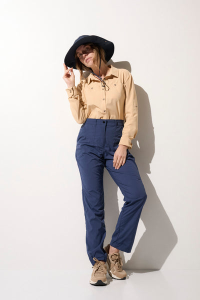 Femme portant un chapeau anti-UV noir et une chemise légère beige, idéale pour les activités en extérieur.