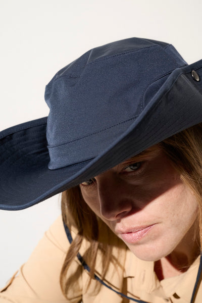 Chapeau anti-UV bleu marine femme, léger et respirant, offrant protection solaire UPF 50+ lors des activités en plein air.