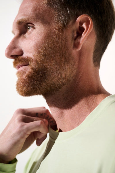 Homme portant un t-shirt anti-UV vert clair UPF 50+, léger et confortable, adapté aux activités extérieures.