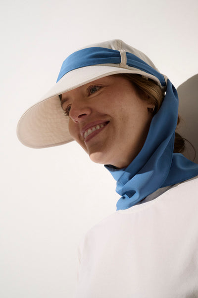 Casquette anti-UV légère pour femme, avec visière large et tour de cou bleu pour une protection solaire élégante.