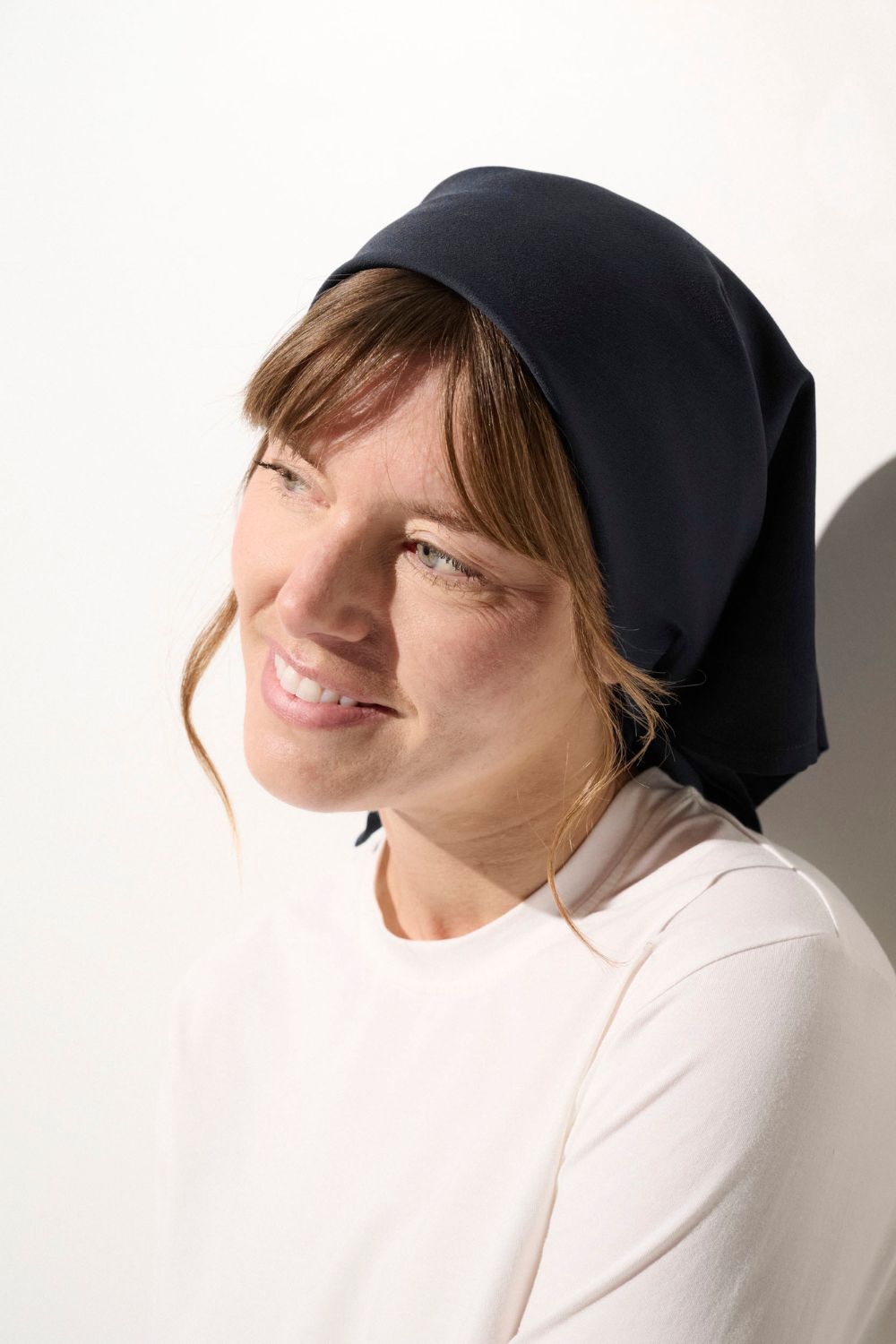 Foulard anti-UV - Positano en noir, porté par une femme pour une élégance et protection solaire quotidienne.