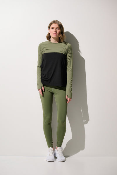 Femme portant un shrug anti-UV - Sequoia vert olive, manches longues, tissu léger, protection solaire UPF 50+.