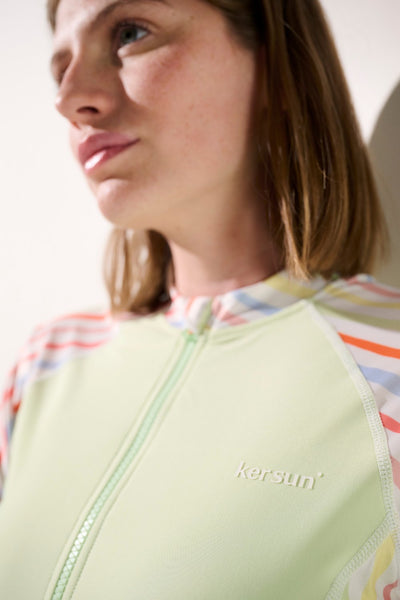 Femme en maillot de bain anti-UV manches longues - Pacific de Ker Sun, couleur vert clair avec motifs colorés, protection solaire.