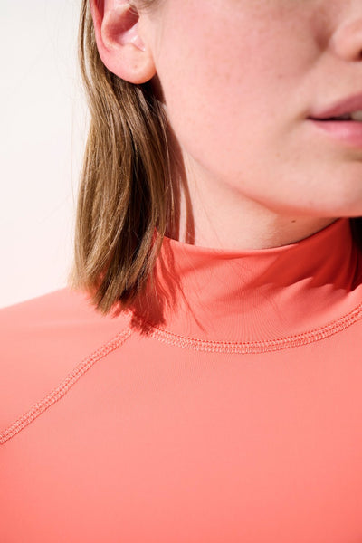 Détail du t-shirt de bain anti-UV - Malibu en lycra corail pour femme, conçu pour protection solaire UPF 50+.