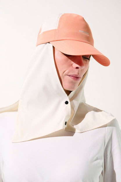 Femme portant une casquette anti-UV bicolore avec protection solaire, idéale pour activités extérieures.