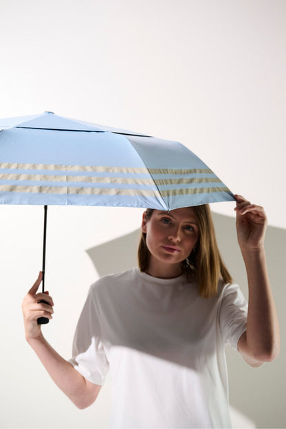 Femme avec une ombrelle anti-UV UPF 50+, offrant protection solaire efficace au quotidien.