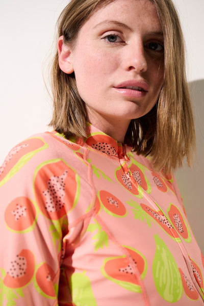 Femme se protégeant du soleil avec une veste de bain anti-UV certifiée UPF 50+.