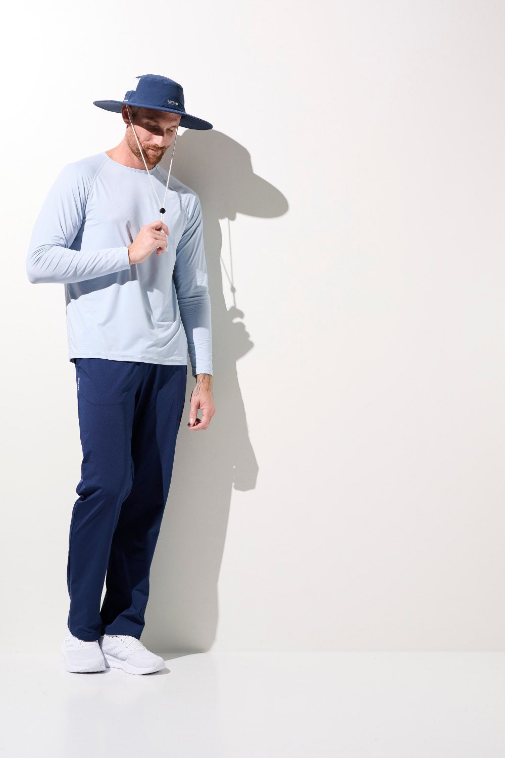 Homme portant un chapeau anti-UV - Oasis et une chemise légère UPF 50+, idéal pour activités en extérieur.