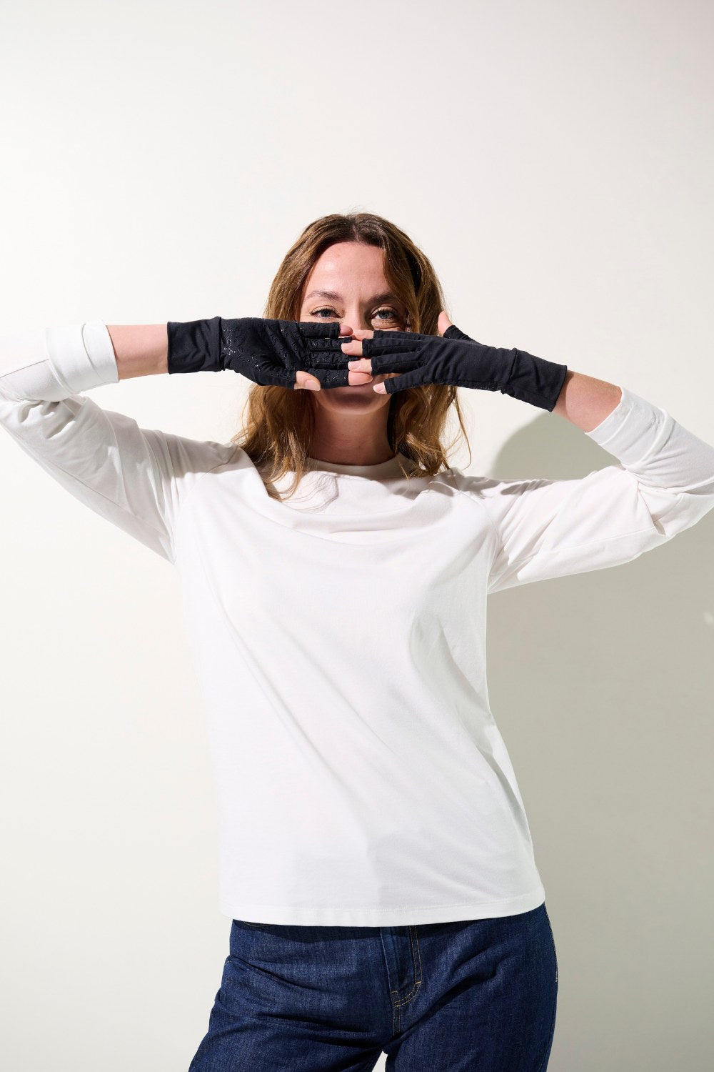 Femme portant des mitaines anti-UV Mojave noires, protégeant ses mains du soleil et offrant un confort optimal.