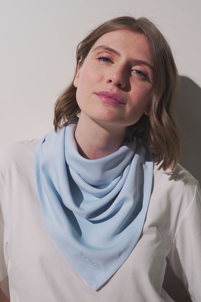 Foulard anti-UV - Positano en couleur bleu clair porté par une femme, élégant et léger, protection solaire UPF 50+.