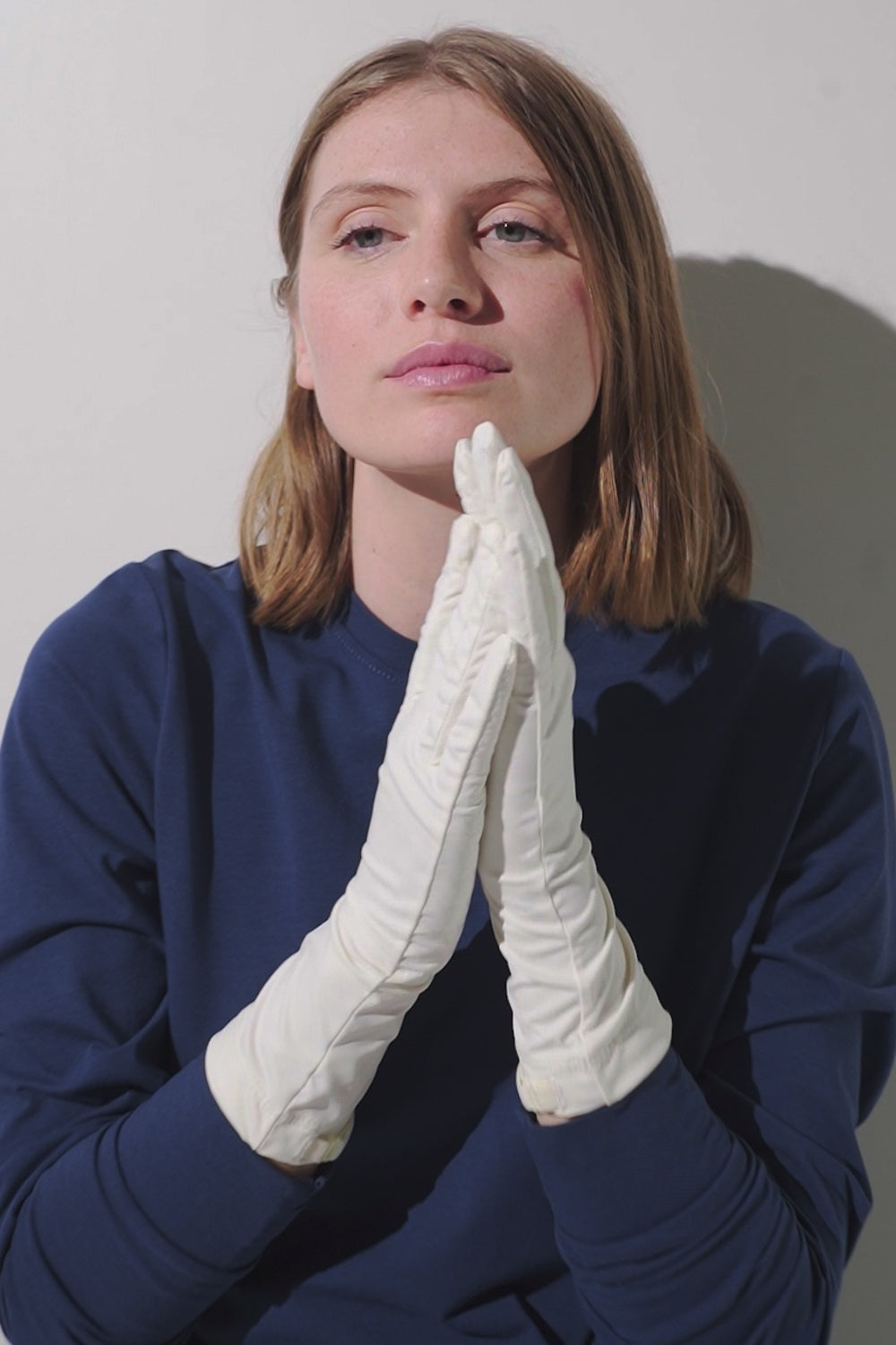 Gants anti-UV - Mojave blancs avec manches longues, portés par une femme pour une élégance et protection solaire.